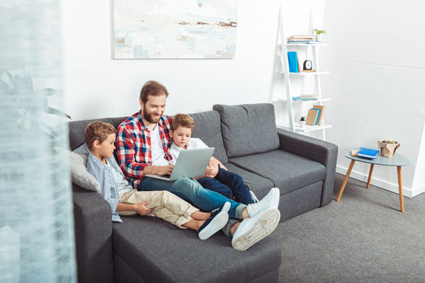 A father and his two sons watching on his laptop