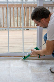 A man is using a caulking gun