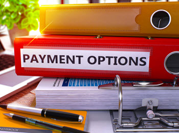 A stack of binders sits on a desk with one labeled "PAYMENT OPTIONS." 