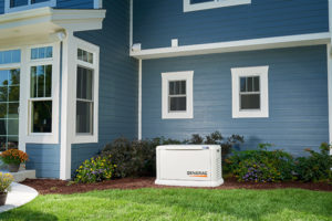 A home generator sits outside a blue house with white trim. 