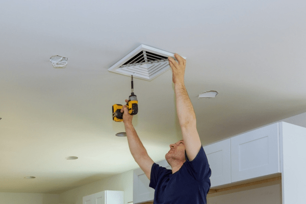 homeowner sealing centralized air condition ceiling vent after inspection