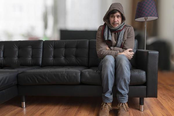 image of a homeowner feeling chilly due to running out of heating oil at home