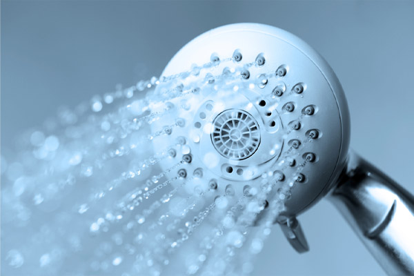 A close-up of a showerhead spraying water. 