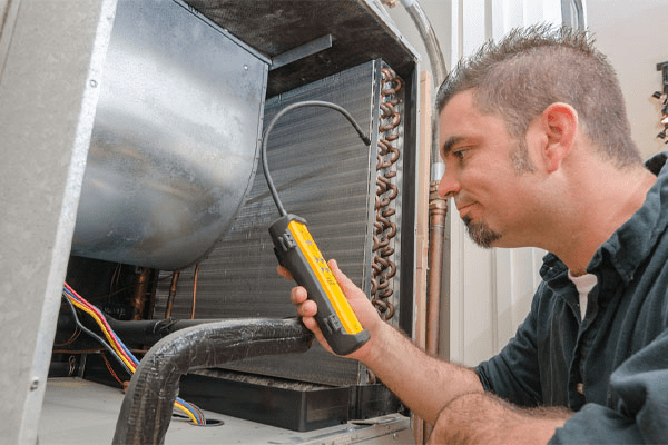 an hvac contractor checking ac refrigerant levels