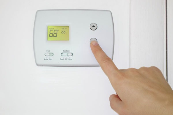 homeowner adjusting thermostat