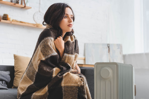 image of homeowner using a space heater for heat during heater malfunction