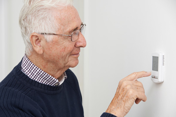 man adjusting thermostat