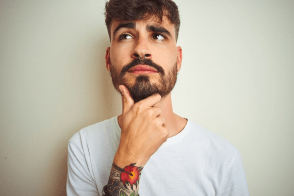 man looking up thinking with hand on chin depicting common propane myths