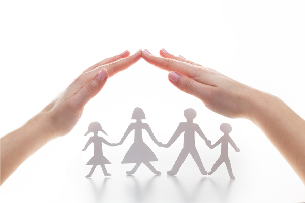 protective roof over a paper cutout of a family