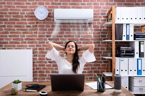 A woman relaxes with hands behind her head