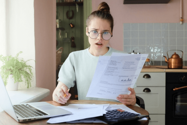 woman with a shocked face looking at energy bill