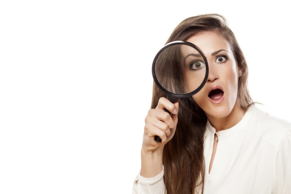 woman with magnifying glass on eyes with a curious look depicting decoding furnace sound meaning