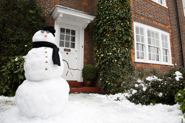 snowman in front of a home that uses oil heat in winter