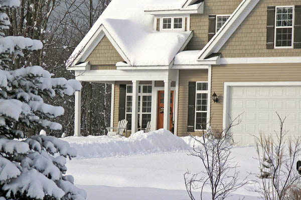 A snow-covered home is shown on a winter day. 