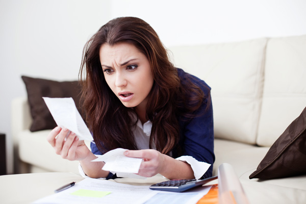 image of woman looking at high heating and cooling bill