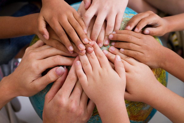 image of kids holding earth depicting why carbon emissions should matter