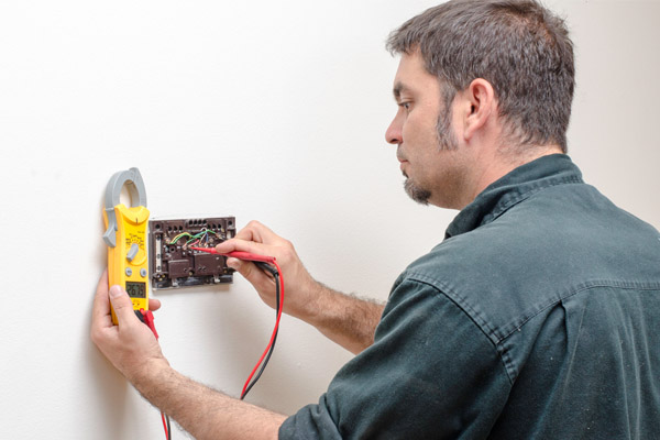 hvac contractor working on thermostat