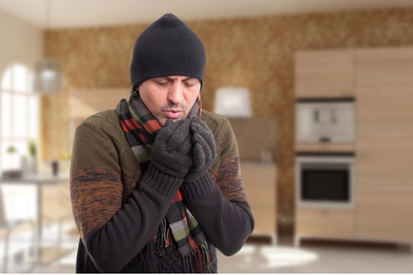 man wearing scarf & beanie indoors due to heating issues at home