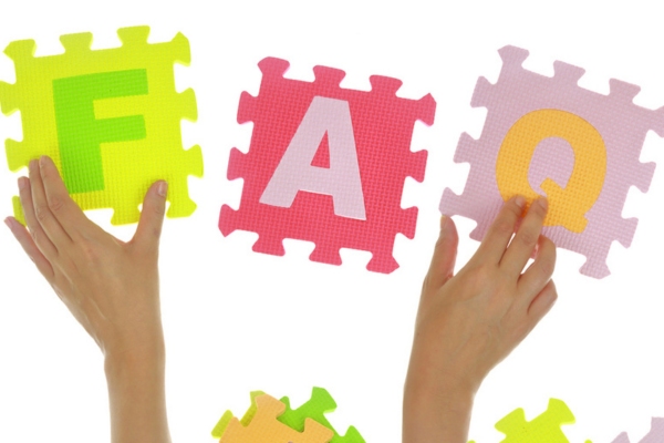 Hands forming word FAQ with foam puzzle pieces