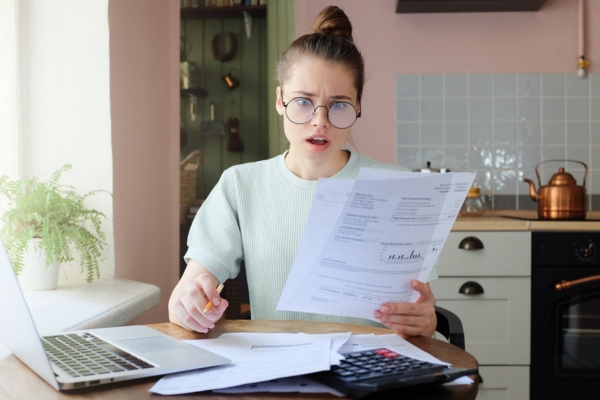 woman with a shocked face looking at energy bill