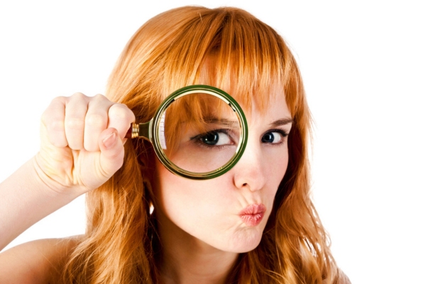 woman looking through magnifying glass depicting signs of aging furnace