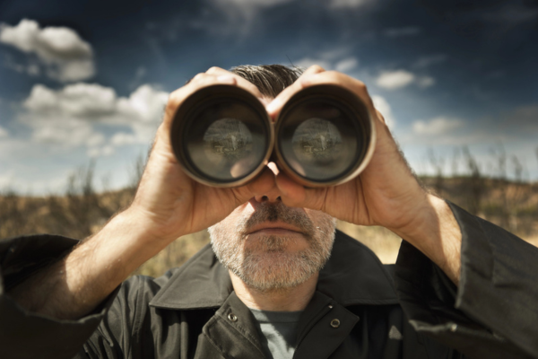 man with binoculars depicting what to look for in an HVAC company