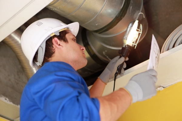 HVAC technician inspecting ductwork