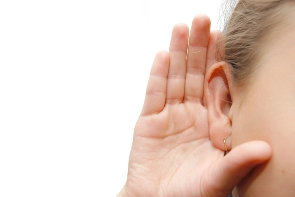 girl listening with her hand on an ear depicting audible signs of ductwork damage