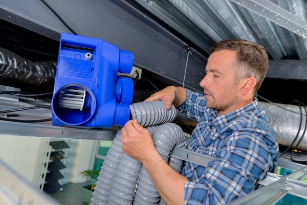 image of a professional HVAC technician tending to a client's ductwork system