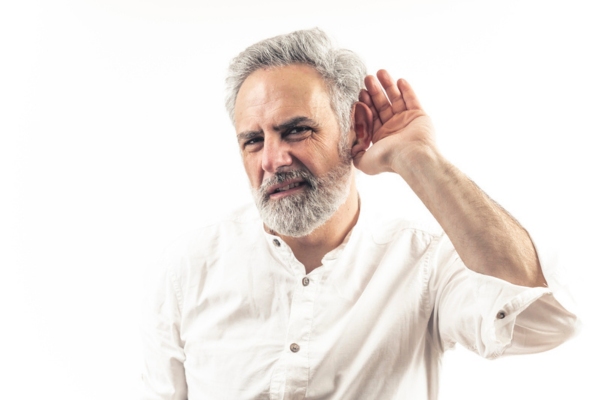 man holding ear up while listening to furnace noises