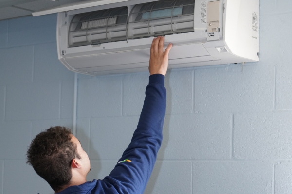 Townsend Energy HVAC technician examining ductless mini-split interior unit