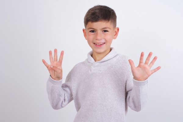 young boy holding 9 fingers up depicting ways to improve winter indoor air quality