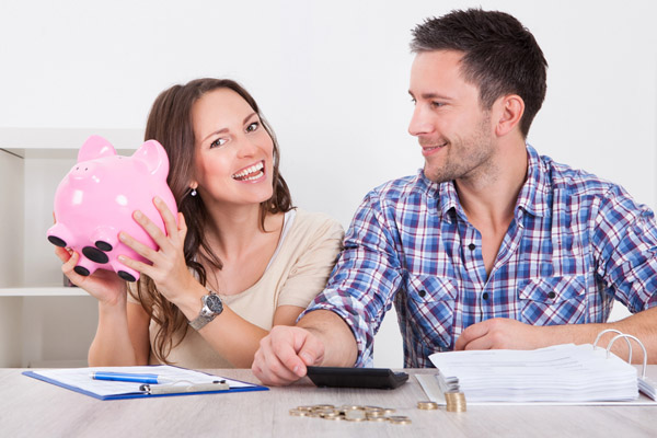 couple with piggy bank depicting saving money with propane heating