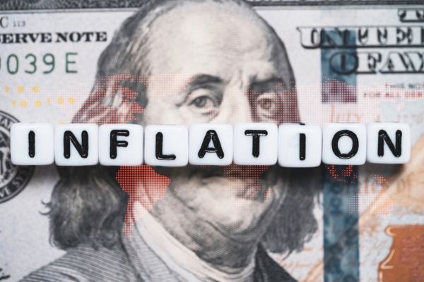 inflation spelled using bead letters on top of a dollar bill