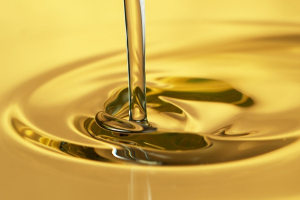 pouring of gold liquid depicting refining process of oil