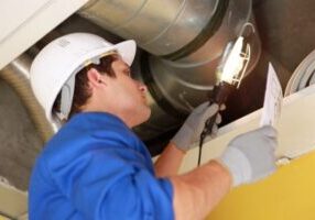 HVAC technician inspecting ductwork