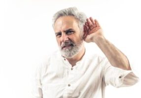 man holding ear up while listening to furnace noises